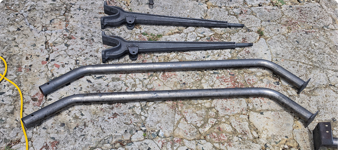 Assorted long metal tools on cracked concrete