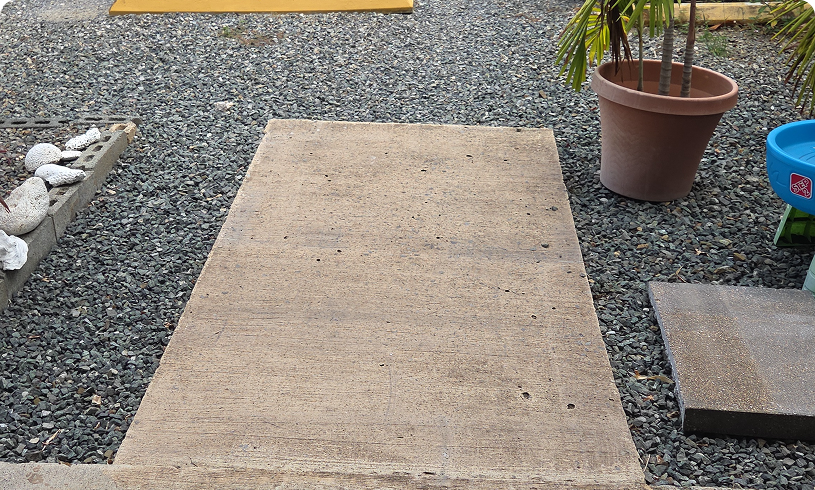 Concrete walkway on gravel with potted plant
