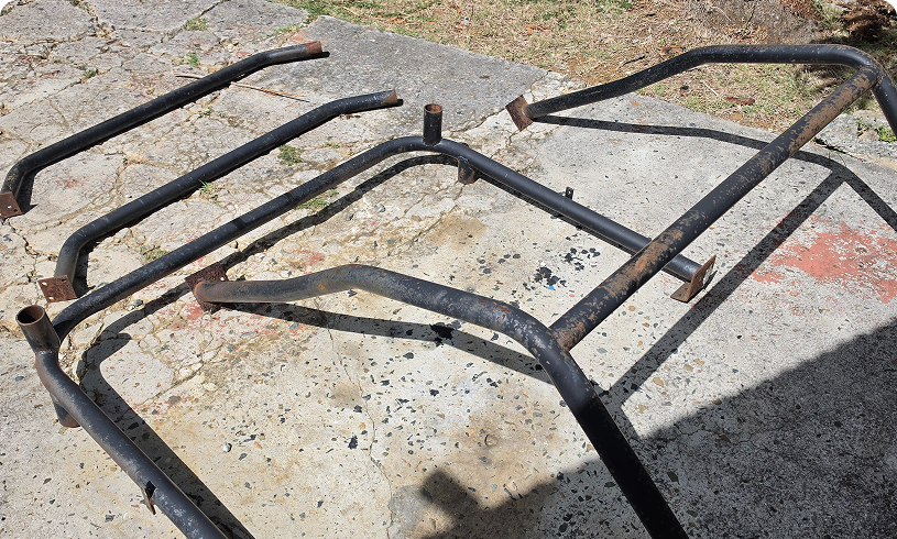Disassembled black tubular metal roll cage sections