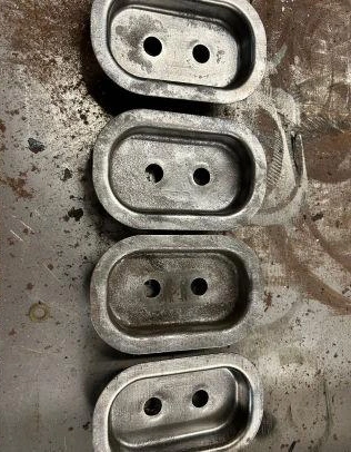 Four metal plates with two holes each.