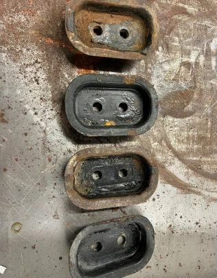 Four rusty, oval-shaped metal pieces.